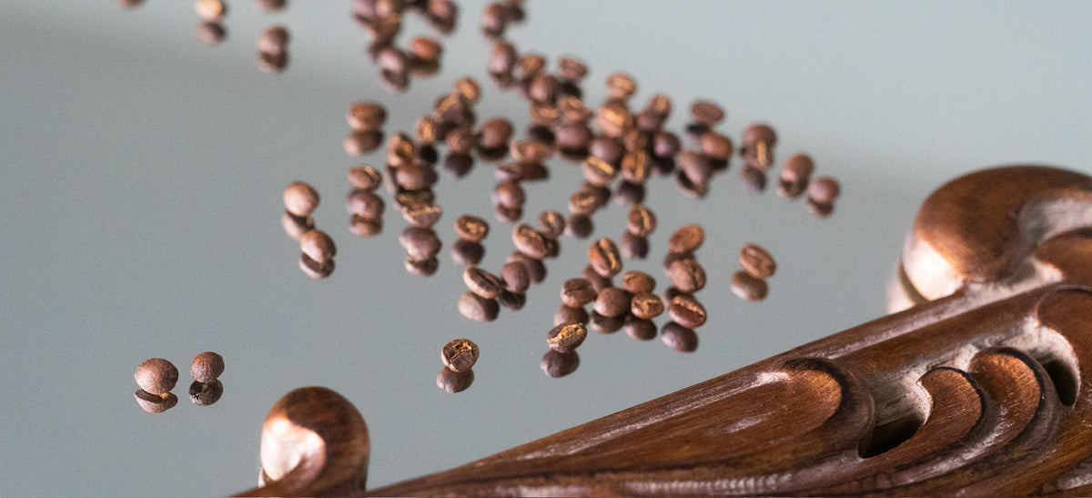 Coffee beans flying over a chocolate swirl - guide to Pensacola, FL coffee roasters by Inheritance Coffee