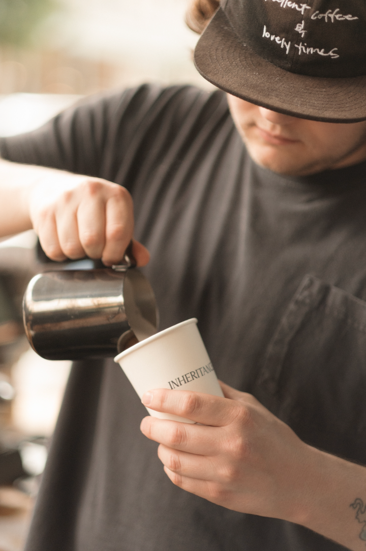 Barista pouring a latte for a guest - first impressions for church hospitality teams from Inheritance Coffee, Pensacola, FL