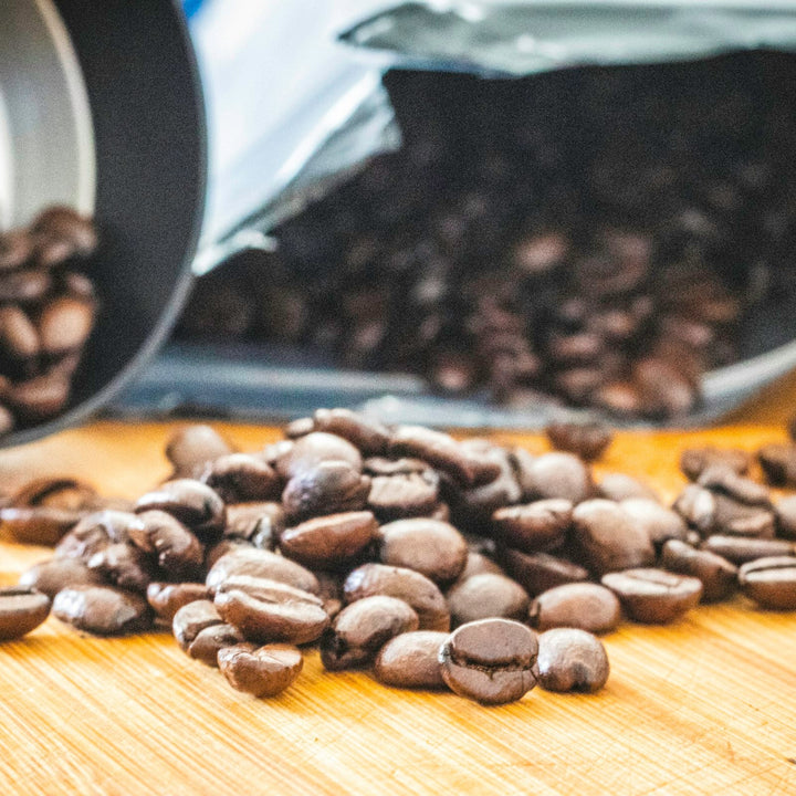 A wide pile of whole roasted coffee beans used to compare a 50/50 Kenya-Ethiopia blend to a single origin