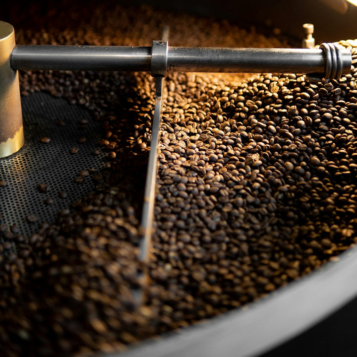Coffee beans turning inside the drum of a production roaster - Inheritance Coffee, Pensacola, FL roaster for cafes, churches and coffee startups