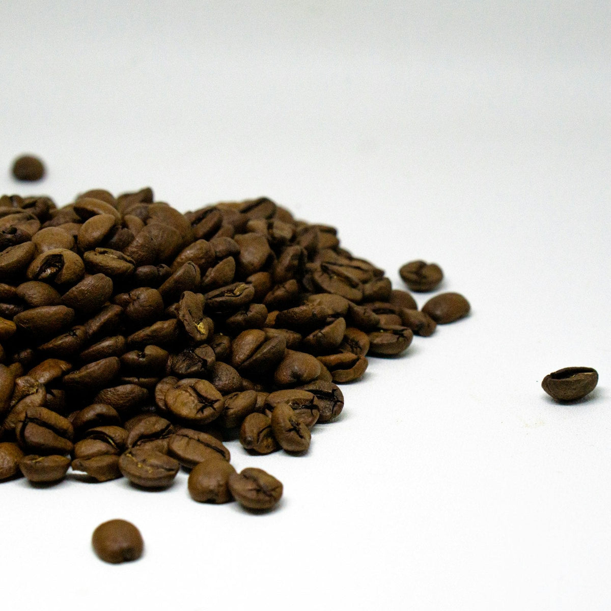 Pile of roasted coffee beans on a white table, the kind of coffee a church can sell under its own name without opening a shop