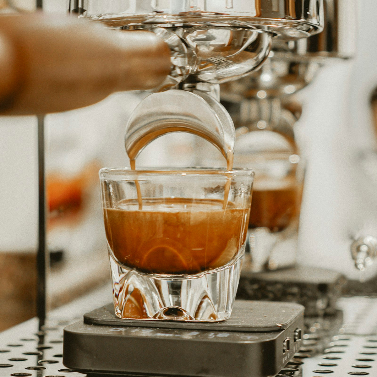 Espresso pouring from a machine into a clear glass