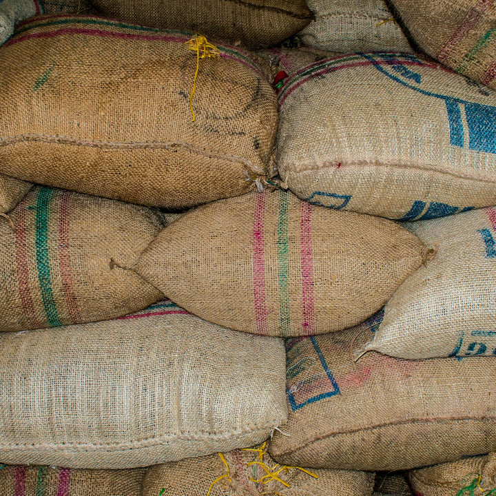 Printed sacks of coffee stacked in a storage warehouse