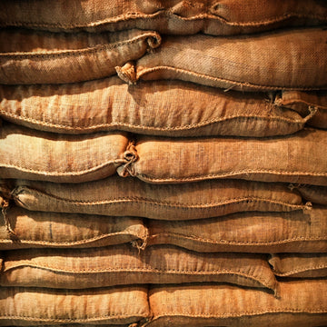 Stacked jute sacks of green coffee held in dry warehouse storage