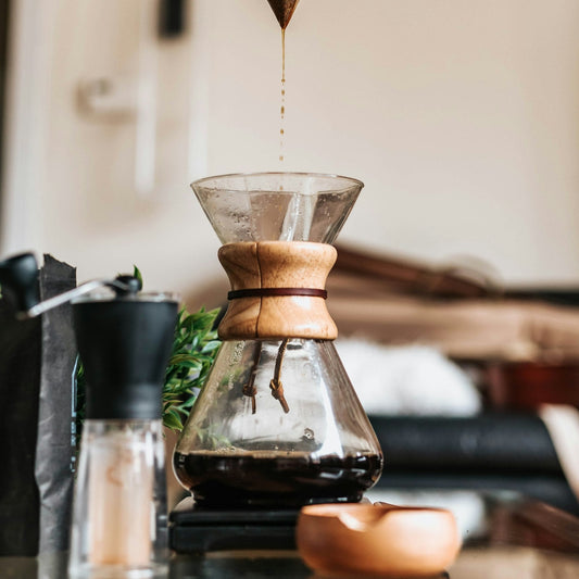 A hand filtering coffee into a funnel-shaped pour-over dripper