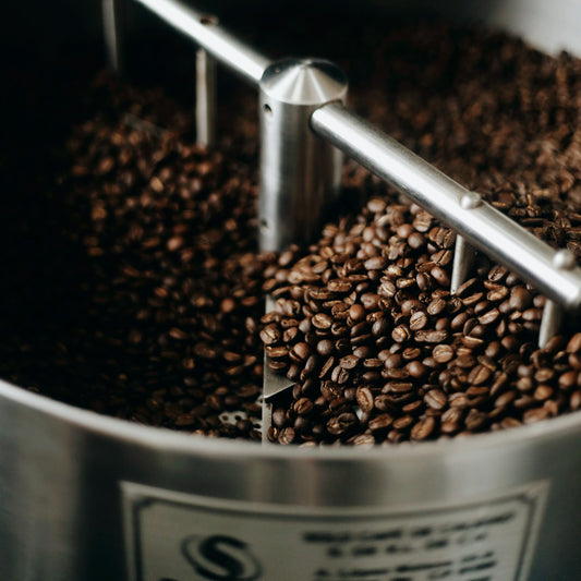Freshly roasted coffee beans cooling on a stainless steel tray after the roast
