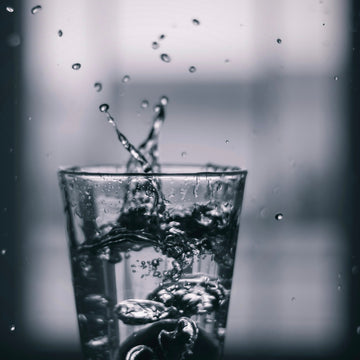 Water pouring into a clear drinking glass, the brewing water that carries every cup of coffee
