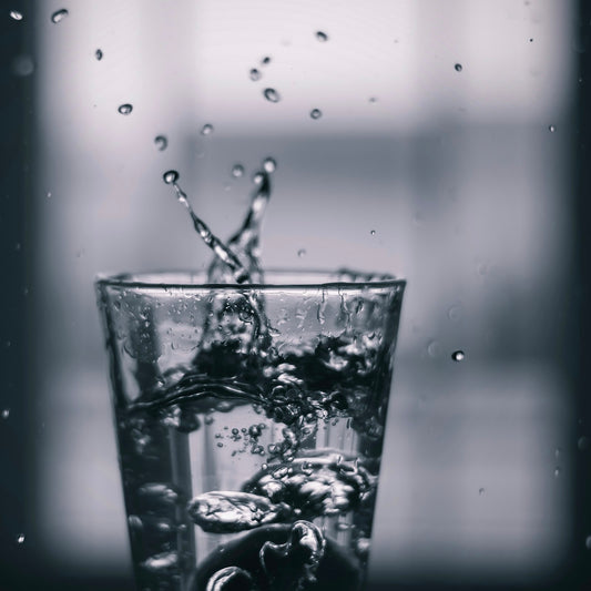 Water pouring into a clear drinking glass, the brewing water that carries every cup of coffee