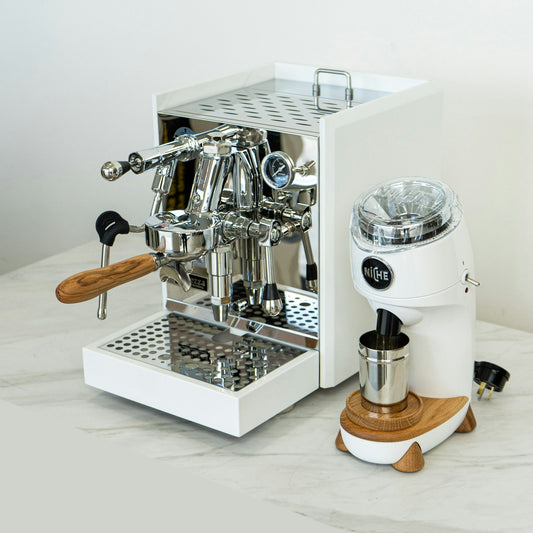 Grey commercial espresso machine and grinder on the white counter of a specialty coffee shop bar