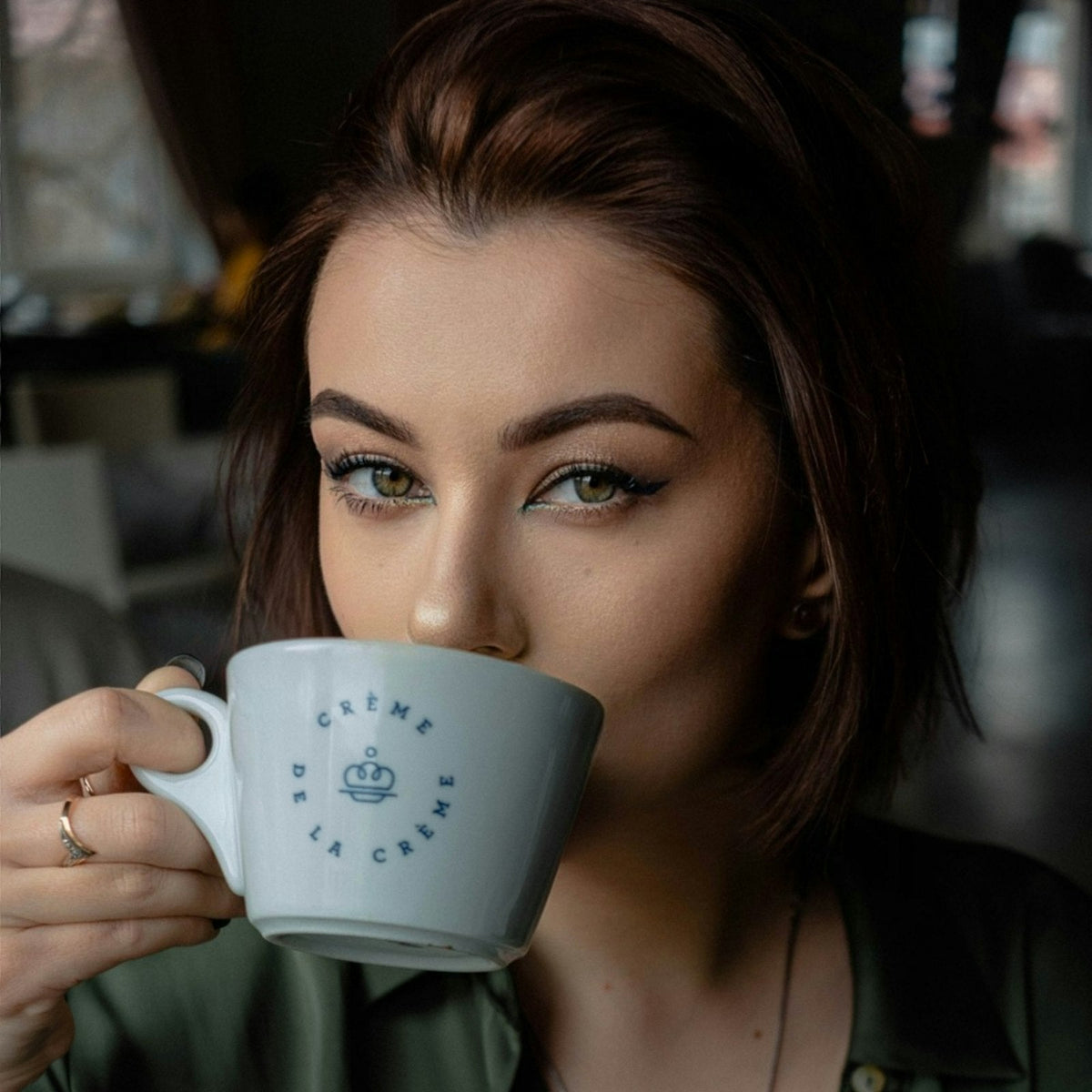 woman holding a cup of coffee up to her face