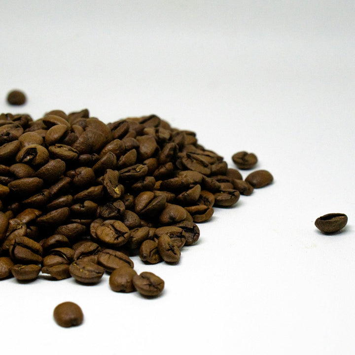 Pile of roasted coffee beans on a white table, the kind of coffee a church can sell under its own name without opening a shop