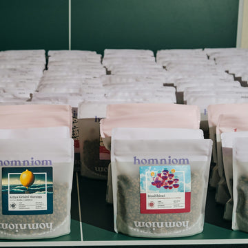 Labeled retail coffee bags standing on a shelf with their information panels facing out