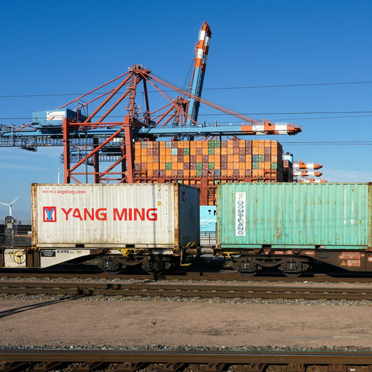 Stacked shipping containers loaded on rail cars at a port