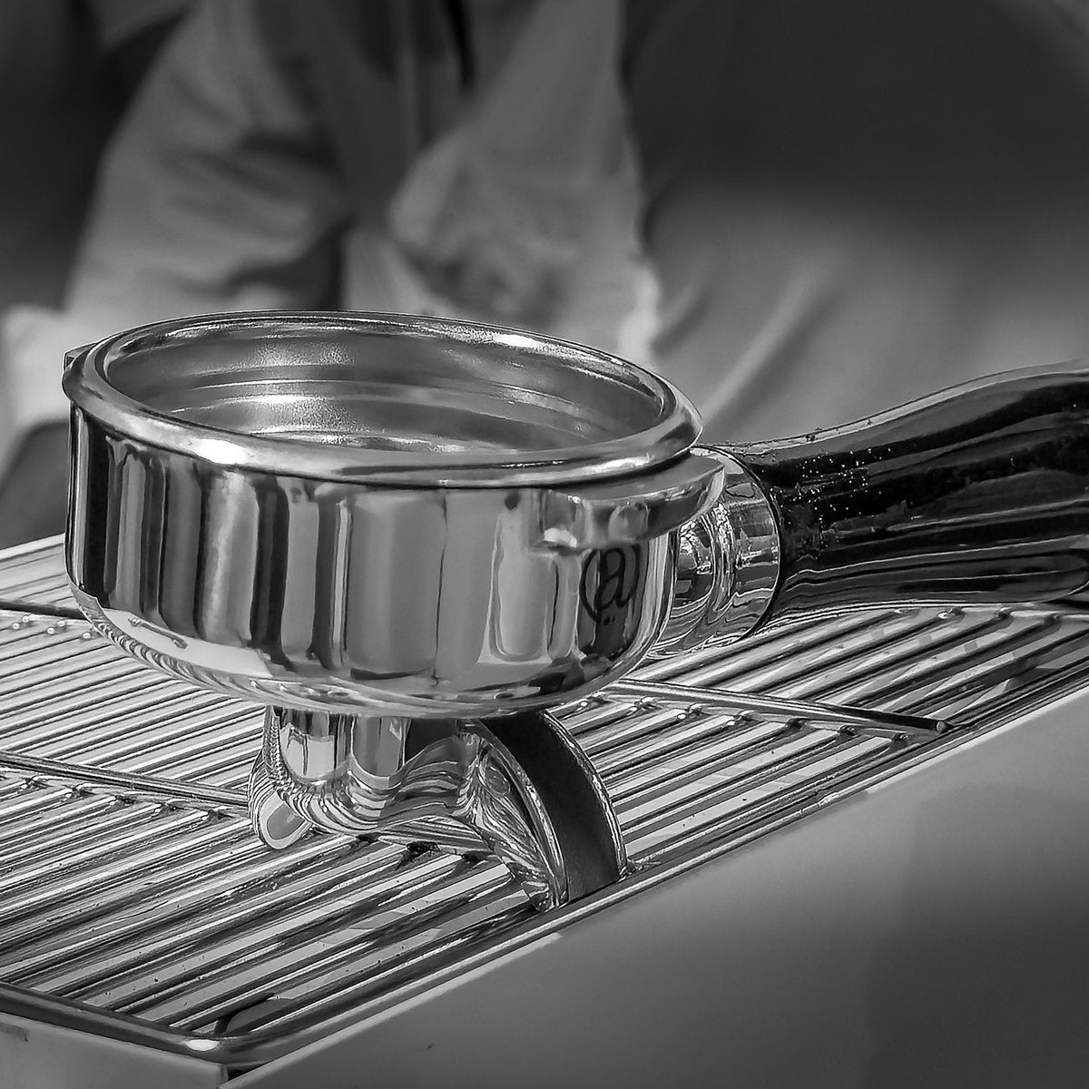 Chrome portafilter resting on a commercial espresso machine