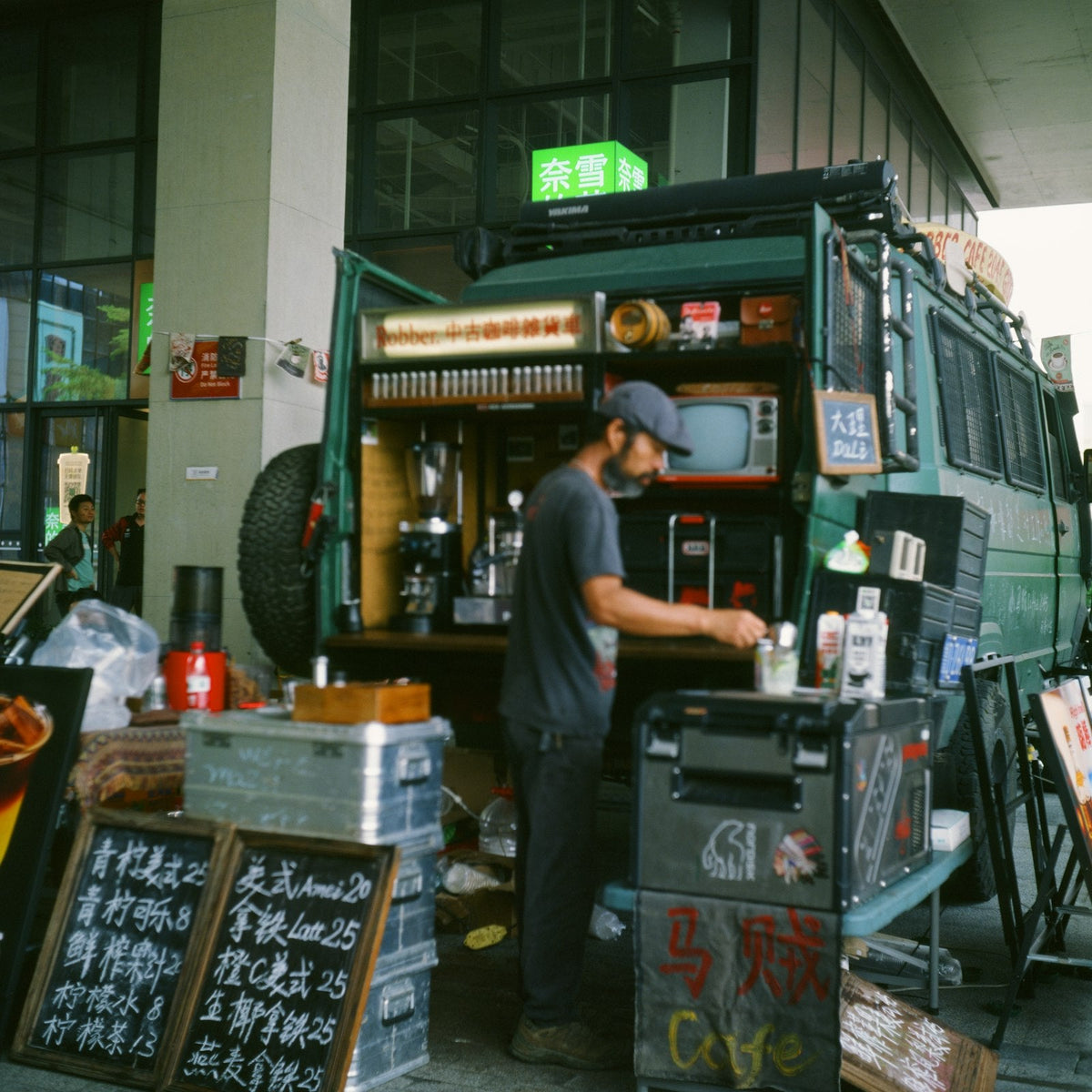 a barista preparing drinks at a mobile coffee van, planning a day of service
