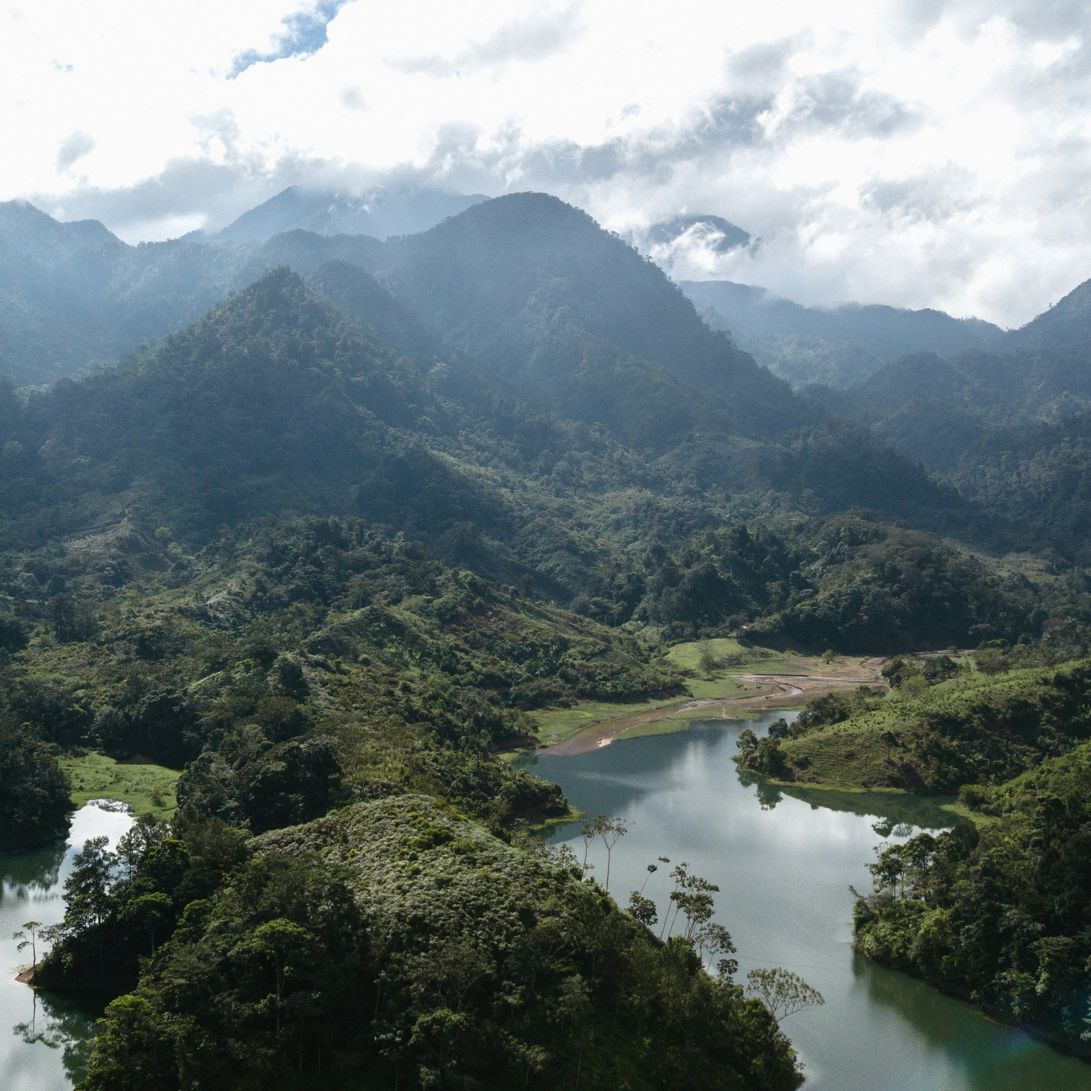 Lush green mountains with a lake surrounded by forest