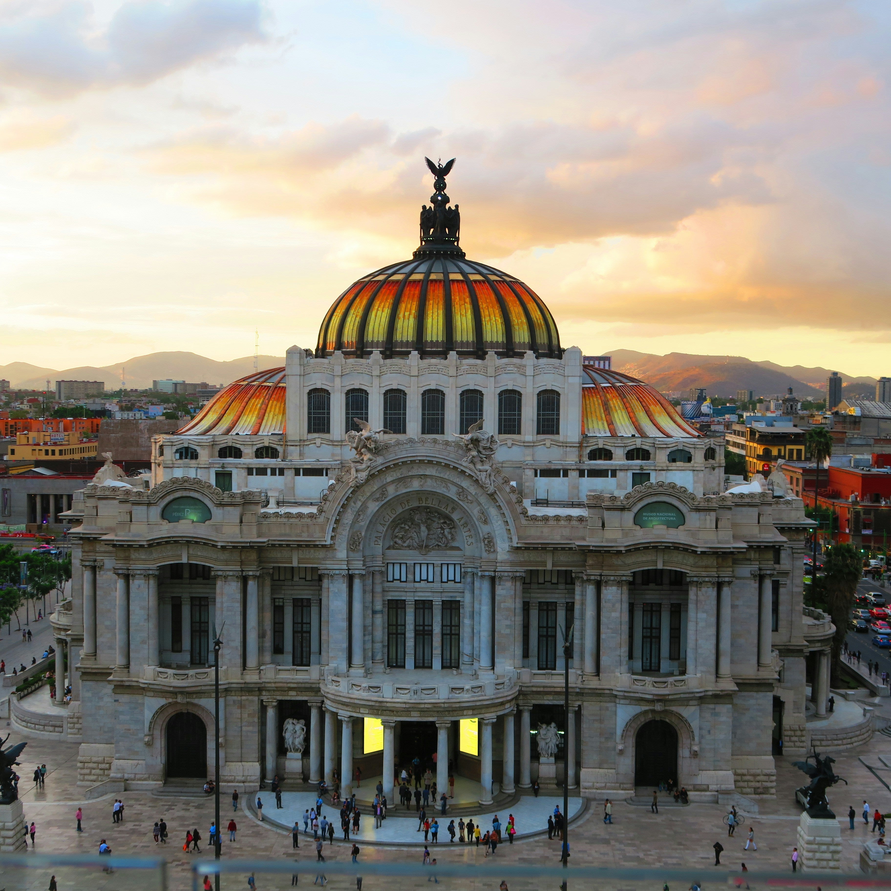 Palacio de Bellas Artes at sunset with a cityscape in the background